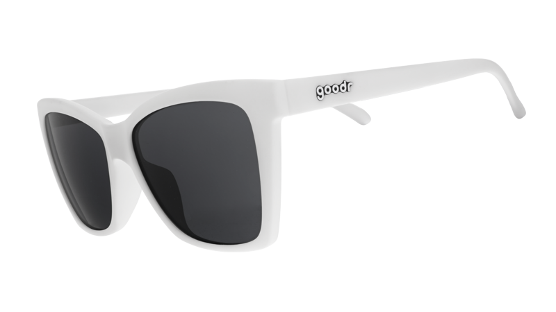 Three-quarter angle view of white angled cat-eye sunglasses with non-reflective black lenses.