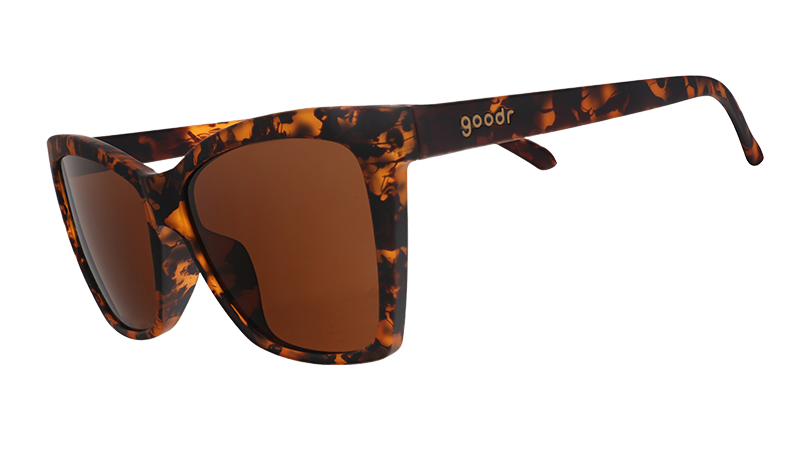 Three-quarter angle view of brown tortoiseshell angled cat-eye sunglasses with non-reflective brown lenses.